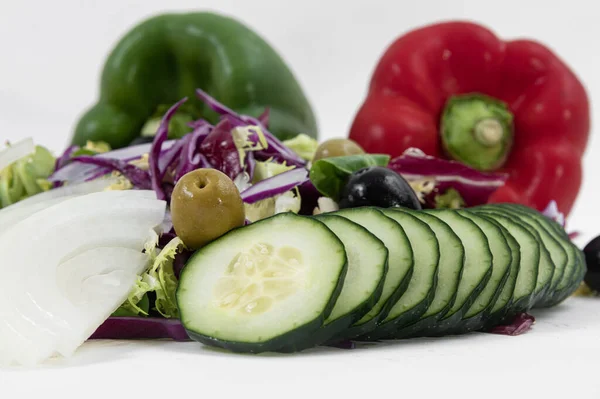 Primer plano de pepino en rodajas, col roja picada, aceitunas, espinacas y cebollas picadas — Foto de Stock