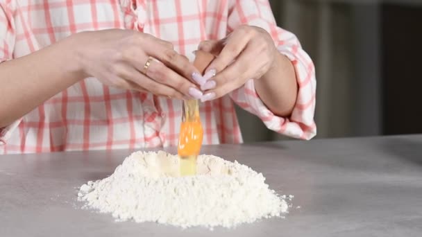 割れた卵を開き スローモーションで小麦粉のマウンドにそれを追加する女性のクローズアップ 料理のコンセプト — ストック動画