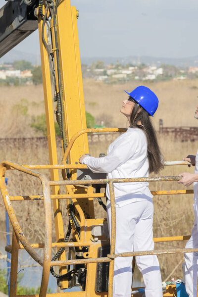 Woman operating the control panel of a telescopic boom lift
