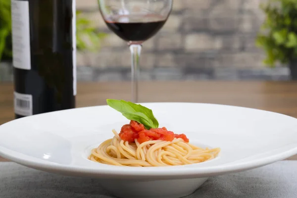 Plato de espagueti con copa de vino y botella — Foto de Stock