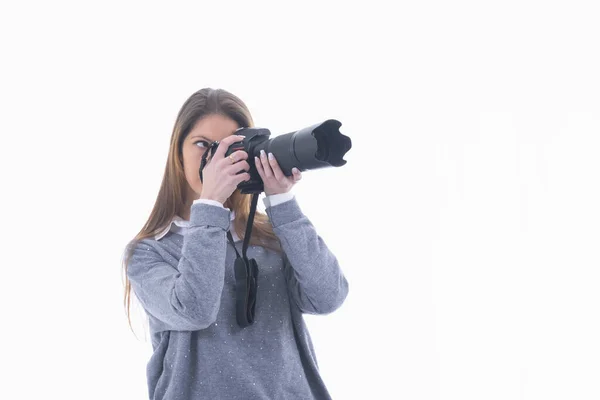 Focused woman looking through a camera viewfinder — Stock Photo, Image