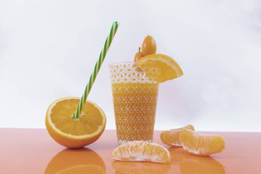 Küçük portakallar, yarım portakal, dilimlenmiş portakal ve portakal suyu - besleyici ve lezzetli portakal suyu