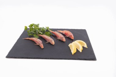 Siyah bir levhada taze kırmızı kefal