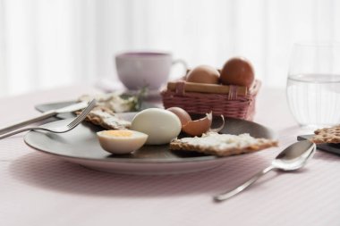 Seramik koyu tabakta haşlanmış yumurtalı diyet tostu kareli masa örtüsü arkaplanı, diyet gıda konsepti, glütensiz