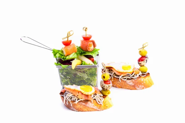 不锈钢做的篮子里塞满了各种蔬菜和鲑鱼 周围有两个开放的三明治 有小精灵 鹌鹑蛋和鲑鱼 背景很浅 健康食品概念 — 图库照片