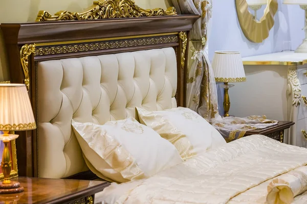 Dormitorio blanco de lujo en estilo antiguo con una rica decoración y lámparas de noche — Foto de Stock