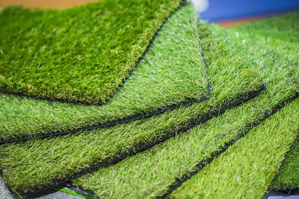 Green artificial turf. Probes examples of artificial turf, floor coverings for playgrounds.