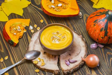 Ahşap arka plan, seçici odak, üstten görünüm krem ve kabak çekirdeği ile kabak kremalı çorba