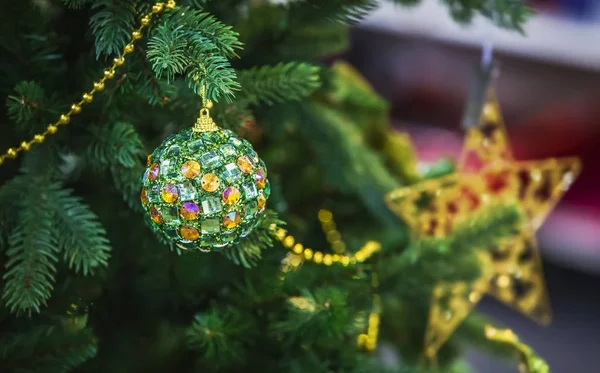 Green christmas ball hanging on a Christmas tree, modern ball decorated with crystals — Stock Photo, Image