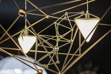 Siyah bir zemin üzerine bir üçgen ve metalik geometrik şekiller şeklinde Modern Avize