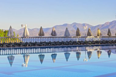 Havuz ve deniz şafak sabah boş şezlong satır. Rahat yüksek katlı otel