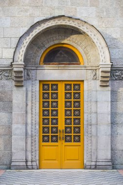 Eski bir kapı dekorasyonu ile. Dekore edilmiş girişinde eski tarihi bina, romantik bir canlanma tarzında yapılmış. Tapınağa sarı ahşap kapı
