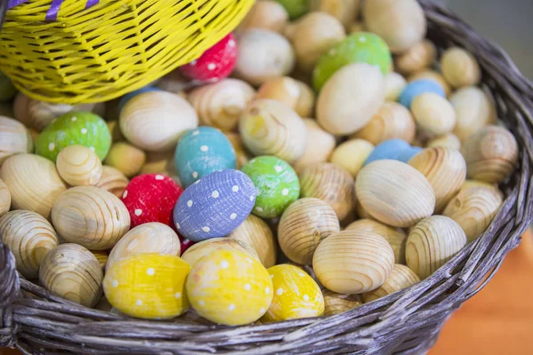Cesta com peças de madeira de ovos de Páscoa, ovos coloridos em cores diferentes — Fotografia de Stock