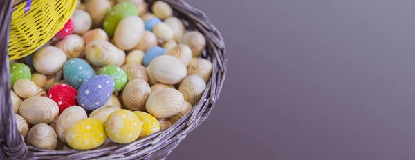 Cesta com peças de madeira de ovos de Páscoa, ovos coloridos em cores diferentes, peça isolada para cartão postal de Páscoa — Fotografia de Stock
