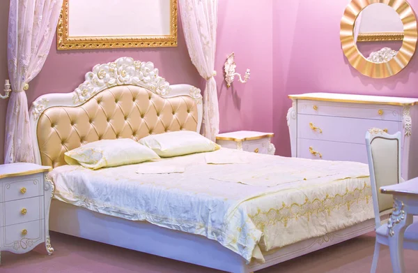 Luxury white and pink bedroom in antique style with rich decor. Интерьер спальни классического стиля в роскошной квартире — стоковое фото