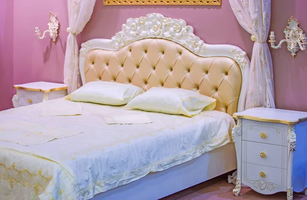 Luxury white and pink bedroom in antique style with rich decor. Интерьер спальни классического стиля в роскошной квартире — стоковое фото