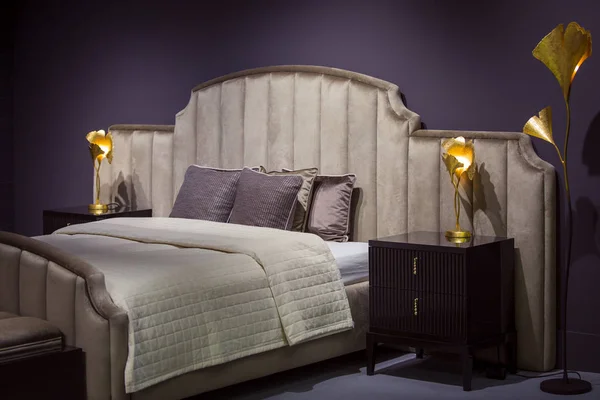 Hermoso dormitorio de diseño moderno en colores oscuros, con luces doradas y lámpara de pie — Foto de Stock
