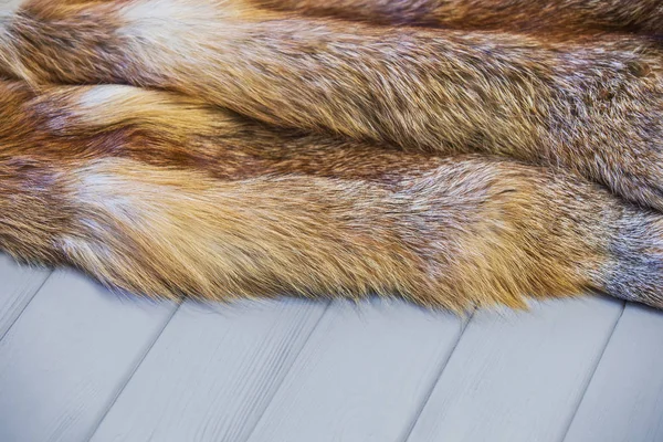 Red fox huid op een houten grijze achtergrond. Mooie vacht van een vos — Stockfoto