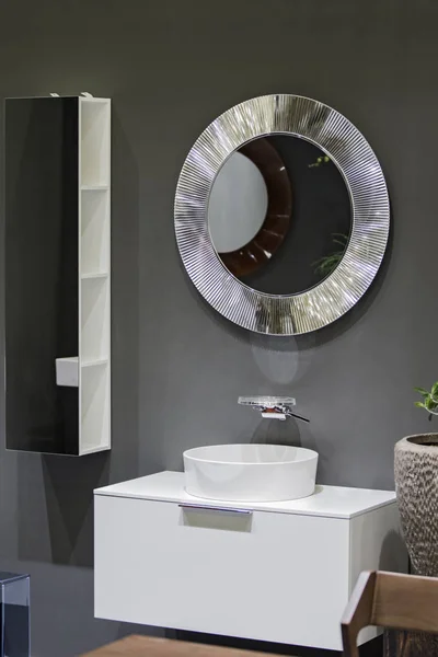 Un hermoso cuarto de baño moderno, un lavabo y un espejo de plata contra una pared de hormigón gris — Foto de Stock
