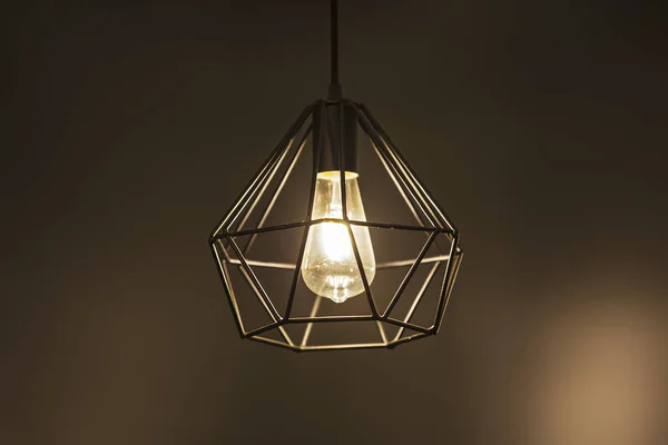 Geometrical chandelier pendant lamp, metallic black modern chandelier, on a brown warm background