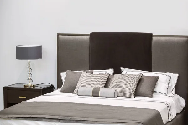 Современный роскошный интерьер спальни. Дизайн номера в отеле с кроватью и оригинальной настольной лампой — стоковое фото