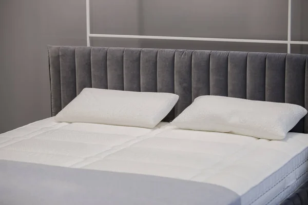 Uma bela cama sem sombra com roupa de cama para colchões publicitários e travesseiros — Fotografia de Stock