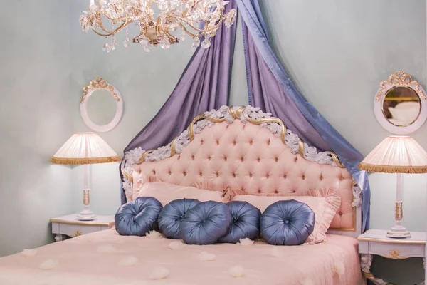 Pequeña habitación rosa princesa con almohadas de satén, lámparas de noche, mesitas de noche, marcos en las paredes. Lujo rico dormitorio interior — Foto de Stock