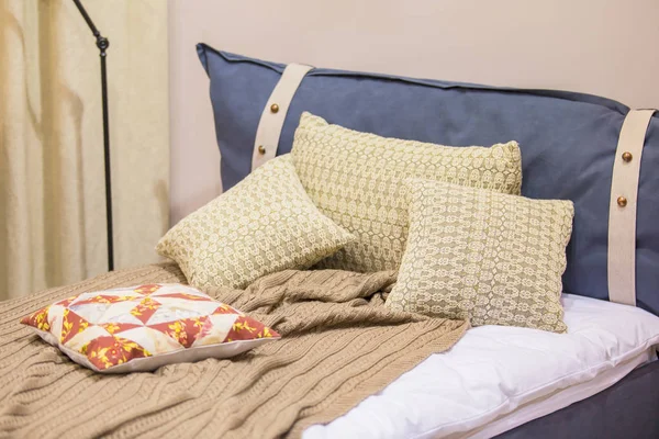 Современный номер для подростка в скандинавском стиле - кровать, подушки в вязаных чехлах, напольная лампа, джинсовая обивка кроватей — стоковое фото