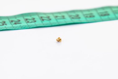 Tek böbrek taşından bir makro ve beyaz arka planda bir cetvel. Oksalat böbrek taşı