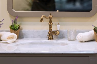 Provence tarzında güzel bir lavabo, altın musluğu ve tesisatı var. Mermer lavabo.