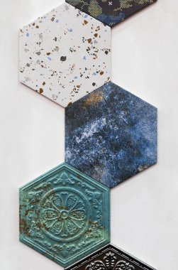 Duvar ve zemin dekorasyonu için farklı desenlere sahip renkli seramik fayanslar. Altıgen beton yüzey arka planı. İç tasarım için süs dokusu.