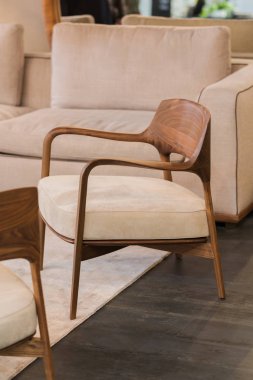 Bej kremalı yumuşak şezlong. Katı ahşap çerçeveli modern oturma odası koltuğu. Modern sandalye tasarımı.