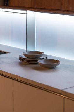 Mutfak tezgahındaki modern tabaklar parlak camdan yapılmış yumuşak ışıkta..