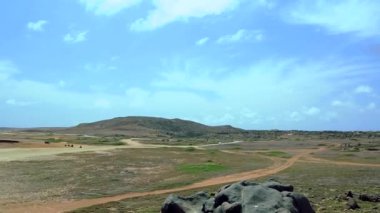 Aruba'nın doğal güzelliği. Kuzey Sahili. Aruba yoldan. Şaşırtıcı kum çöl manzara mavi gökyüzü ve bulutlar beyaz arka plan üzerinde. 