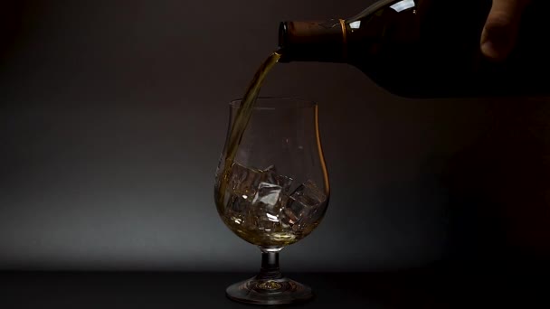 短片中 威士忌倒入郁金香杯中 冰封在黑色背景中 慢动作 漂亮的背景 酒精概念 — 图库视频影像