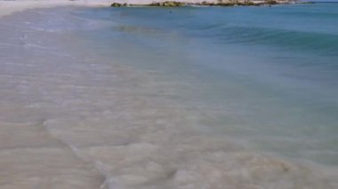 Karayip denizindeki büyük dalga kıyıları kırıyor. Turkuaz deniz suyu ve mavi gökyüzü. Aruba Adası 'nın Kartal Sahili. Güzel doğa arkaplanı.