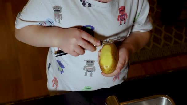 Kortfilm Som Visar Ett Barn Som Lär Sig Skala Potatis — Stockvideo