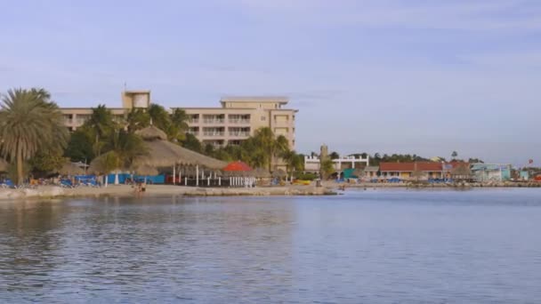酒店区域的美丽概览 美丽的建筑 白色沙滩 日光浴床和蓝天背景下的碧绿水面 库拉索岛 Willemstad 2019 — 图库视频影像