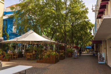 Willemstad caddelerinden birinde güzel bir açık hava kafesi manzarası var. Güzel binalar ve arka planda yeşil ağaçlar. Konsepti tüketiyorum. Turizm konsepti. Willemstad. Curasao. 09.19. 2019