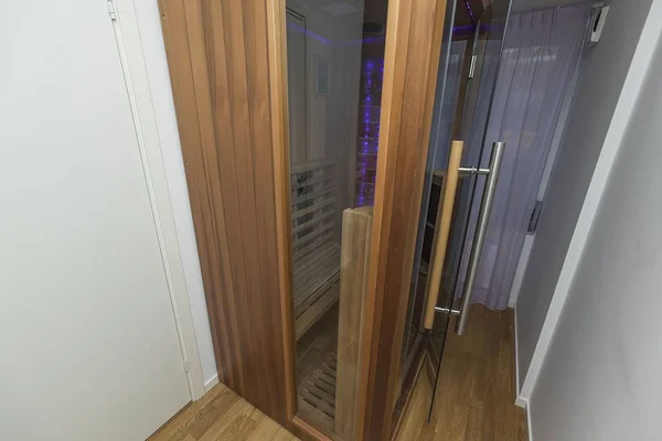 Infrared sauna interior close up view. Wooden walls and bench, ceramic heaters. Healthy lifestyle concept.