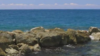 Taşların üzerinde fren yapan dalgaların muhteşem manzarası. Atlantik Okyanusu 'nun turkuaz suyu ve mavi arka planda büyük kayalar. Willemstad. Curacao.