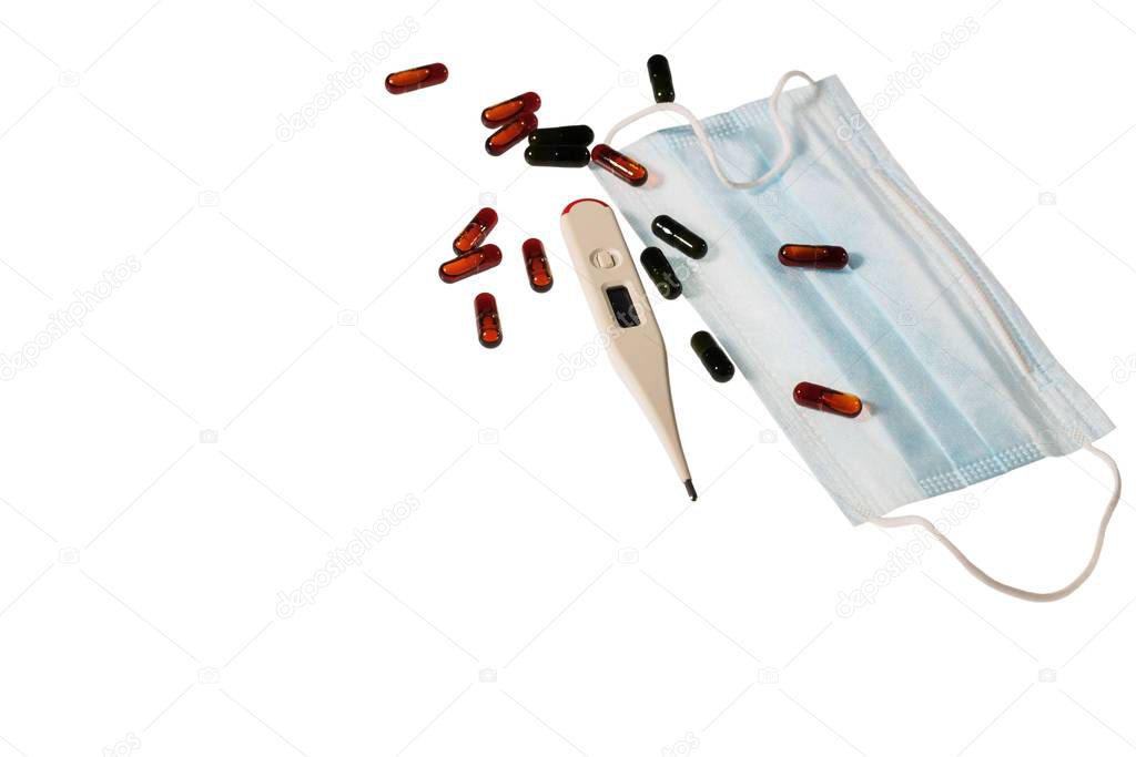 Close up view of face mask , colorful pills and white thermometer isolated on white background. Health concept.