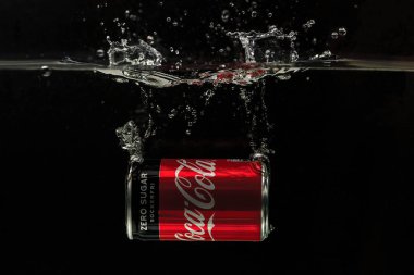 Suya düşen teneke kutunun yakın görüntüsü. Coca Cola. İsveç. Uppsala. 03.14.2020.