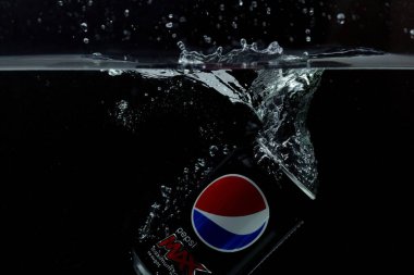 Suya düşen teneke kutunun yakın görüntüsü. Pepsi Kola. İsveç. Uppsala. 03.14.2020.