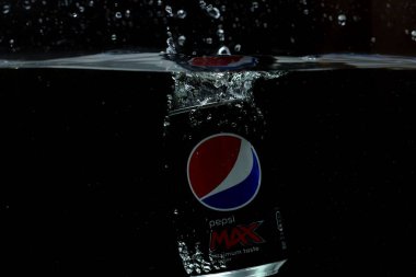 Suya düşen teneke kutunun yakın görüntüsü. Pepsi Kola. İsveç. Uppsala. 03.14.2020.