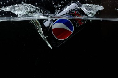 Suya düşen teneke kutunun yakın görüntüsü. Pepsi Kola. İsveç. Uppsala. 03.14.2020.