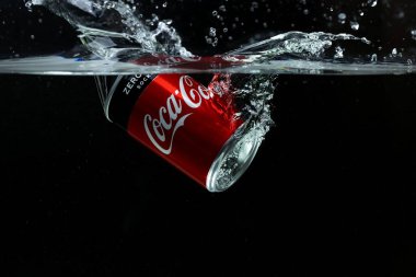 Suya düşen teneke kutunun yakın görüntüsü. Coca Cola. İsveç. Uppsala. 03.14.2020.