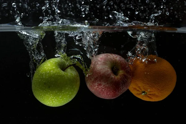 Vista Cerca Frutas Colores Que Caen Agua Sobre Fondo Negro — Foto de Stock