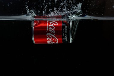 Suya düşen teneke kutunun yakın görüntüsü. Coca Cola. İsveç. Uppsala. 03.14.2020.