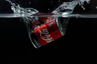 Suya düşen teneke kutunun yakın görüntüsü. Coca Cola. İsveç. Uppsala. 03.14.2020.